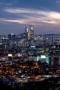 视频展台推荐韩国犯罪剧封面，城市夜景霓虹灯光，侦探人物背影站在雨中街道